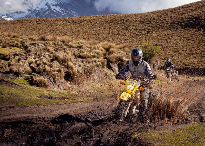 Adventure Motorcyclist riding a Suzuki DR650 in the mud in Ecuador Andes