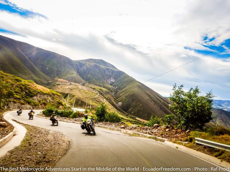 Group motorcycle tour riding on curvy canyon road in Ecuador