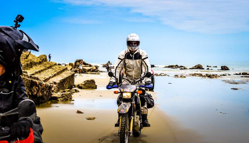 Suzuki DR650 riding on rocky beach near san clemente ecuador