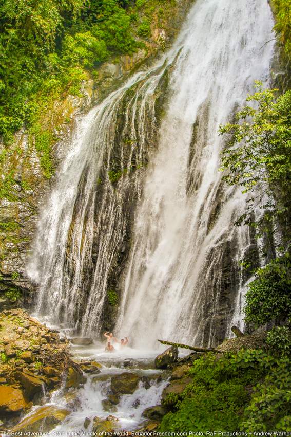 guys on a motorcycle adventure tour swimming in a waterfall