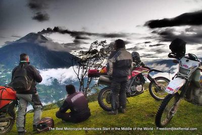 motorcycle tour group watching a volcano erupt in ecuador