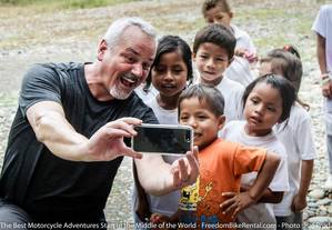 Kids n hte amazon taking photo selfie with a motorcycle tour participant