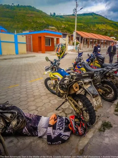 motorcyclist resting from challenging dual sport motorcycle ride in ecuador