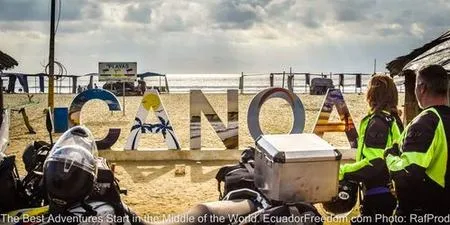 Canoa beach with two motorcyclists arriving at the Pacific Coast in Ecuador