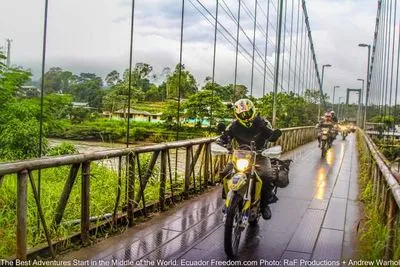 motorcycles crossing metal bridge in puerto misahualli ecuador in the amazon basin