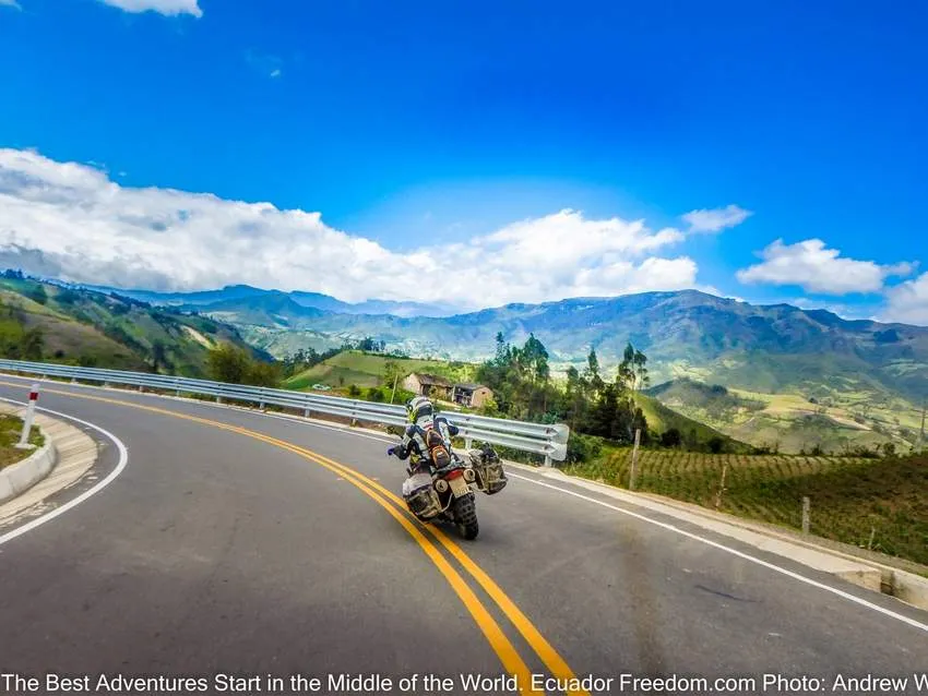 adventure motorcyclist in ecuador in curve heading down in elevation