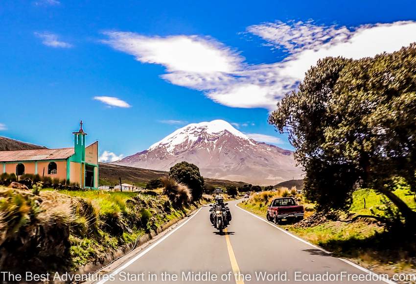 Two motorcyclists riding a BMW F800GS two up with Chimborazo volcano in background in ecuador