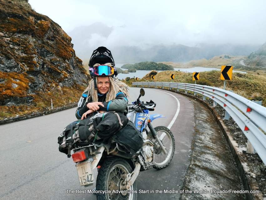 woman adventure motorcycle rider at high elevation lake in ecuador